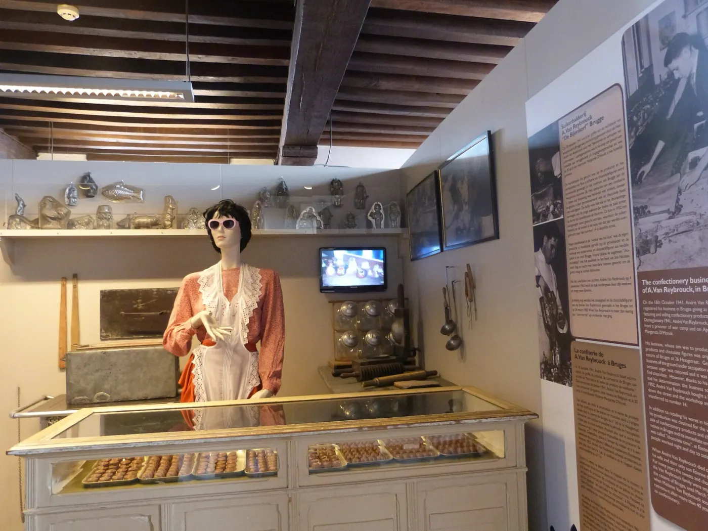 Inside the Choco-Story museum: an old praline counter with a figure of a shop assistant