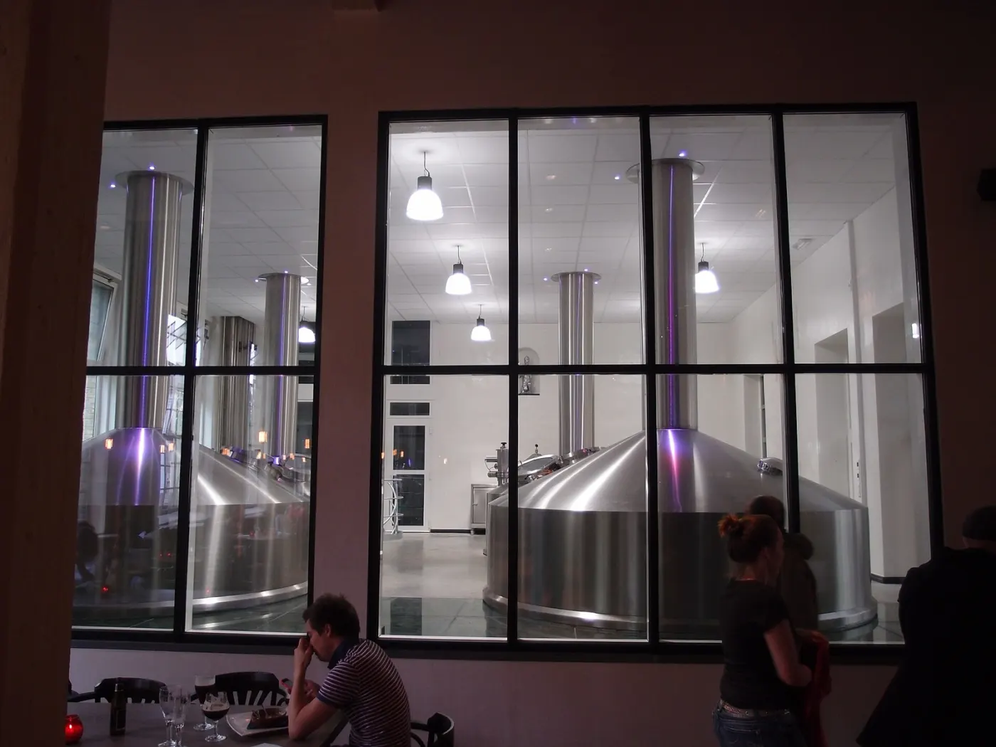 The steel brewing kettles of De Halve Maan behind tall windows