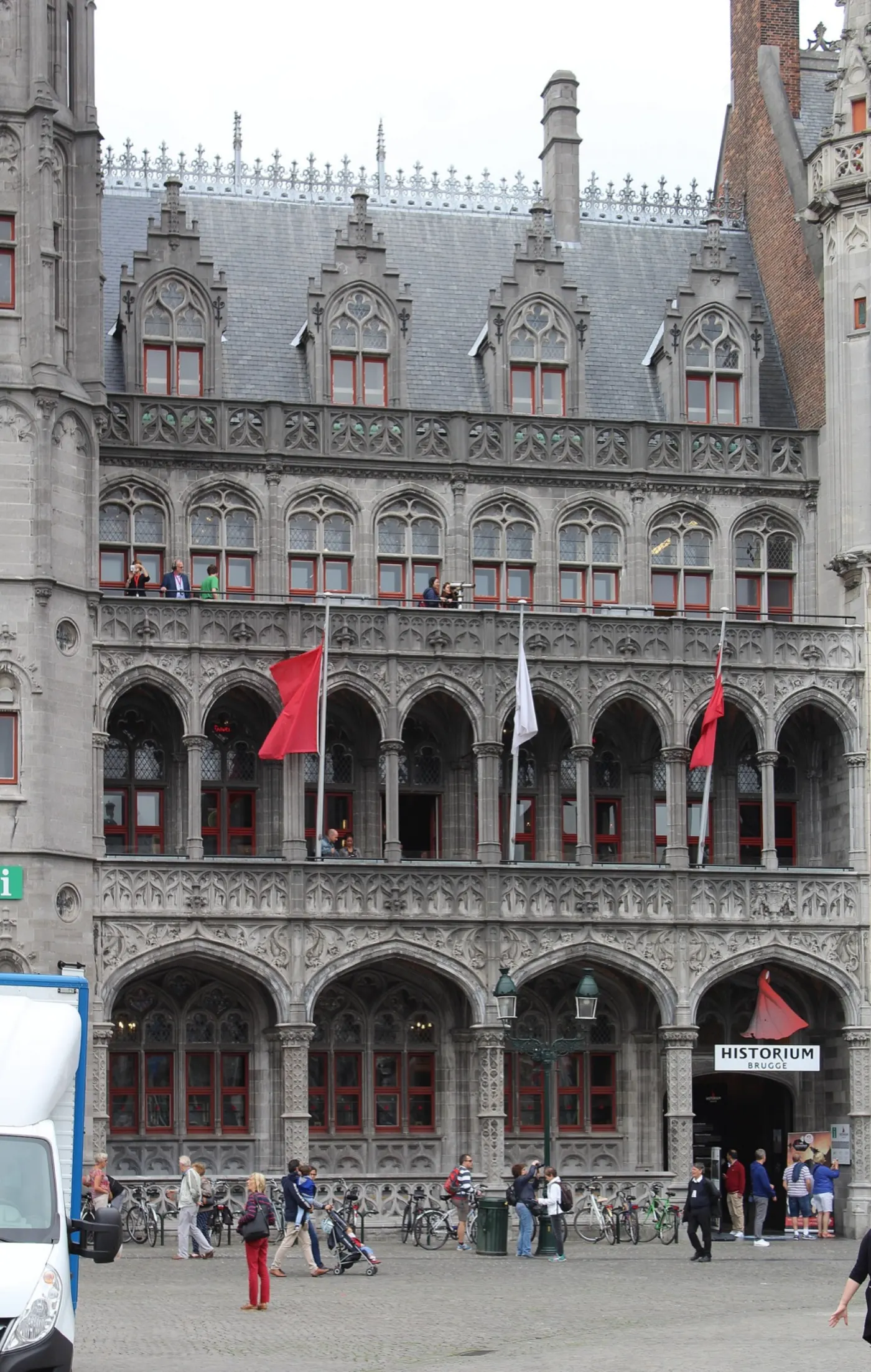 The Historium on the Markt: a grey neo-Gothic front with arched windows and red flags